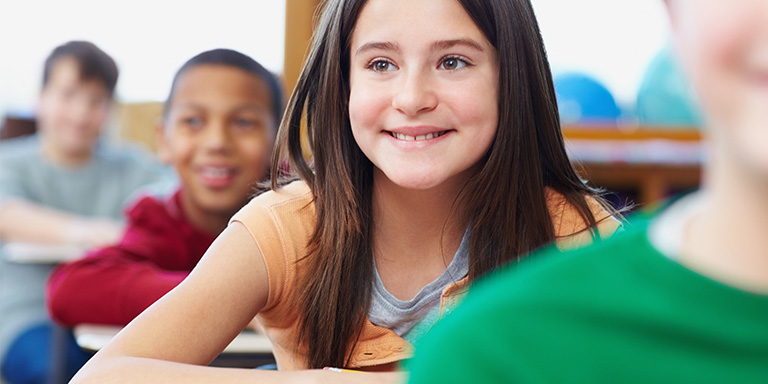 Girl with Asperger's / Autism Spectrum Disorder enjoying learning in school classroom